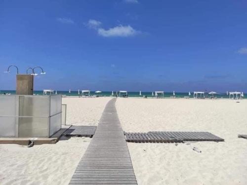 a boardwalk on a beach with the ocean in the background at North coast sedra resort villa قريه سيدرا الساحل الشمالي in Alexandria