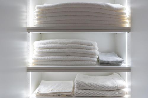 a closet filled with white towels on a shelf at Downtown Luxury Retreat in Ljubljana