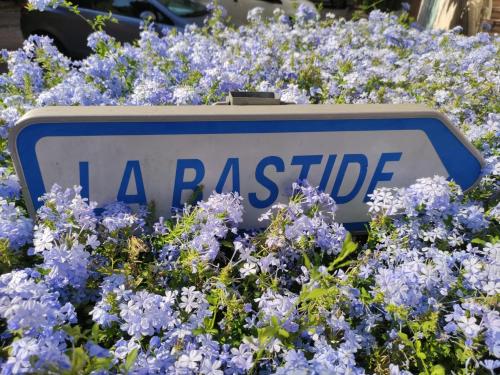 a sign in a bunch of blue flowers at La Bastide, 100m des rues piétonnes, jardin in Sanary-sur-Mer