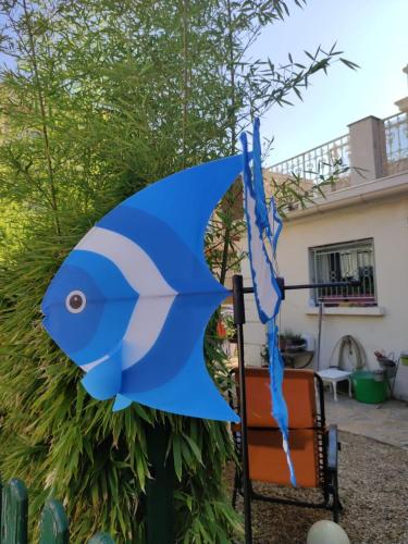 un parapluie bleu en forme de poisson suspendu à une chaise dans l'établissement La Bastide, 100m des rues piétonnes, jardin, à Sanary-sur-Mer