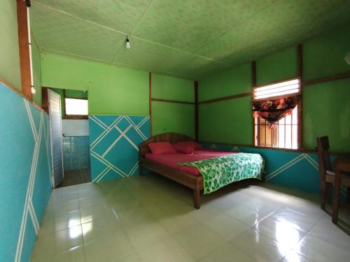 1 dormitorio con 1 cama en una habitación con paredes verdes en Green Lodge Tangkahan, en Tangkahan