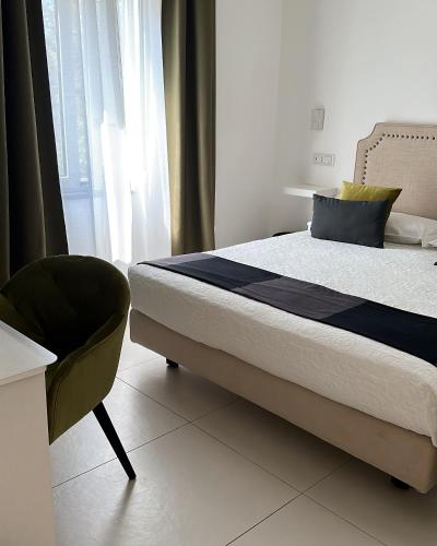 a bedroom with a bed and a chair and a window at Ravello 23 Accommodation in Ravello