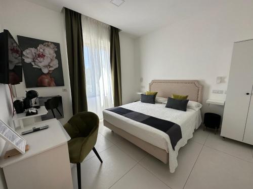 ラヴェッロにあるRavello 23 Accommodationのベッドとデスクが備わるホテルルームと
