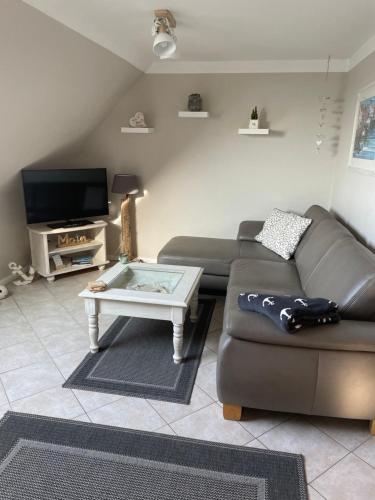 ein Wohnzimmer mit einem Sofa und einem Couchtisch in der Unterkunft Ferienwohnung Petersen in Nordstrand