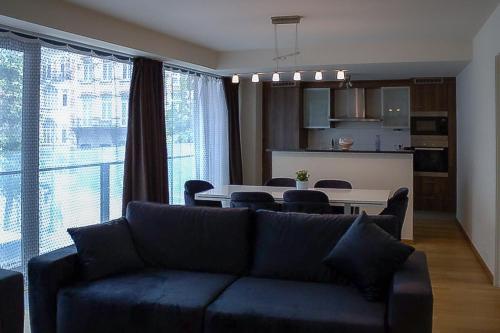 ein Wohnzimmer mit einem Sofa und einem Tisch in der Unterkunft européenne union résidence in Brüssel