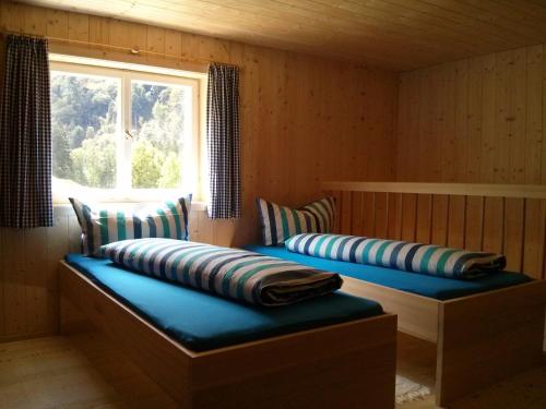 2 Betten in einem Zimmer mit Fenster in der Unterkunft Löchle. Ferienhütte im Bregenzerwald, Andelsbuch in Andelsbuch