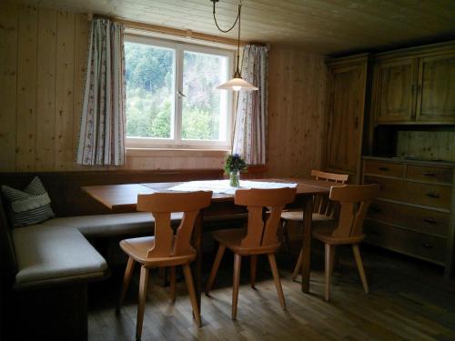 eine Küche mit einem Tisch und Stühlen sowie einem Fenster in der Unterkunft Löchle. Ferienhütte im Bregenzerwald, Andelsbuch in Andelsbuch