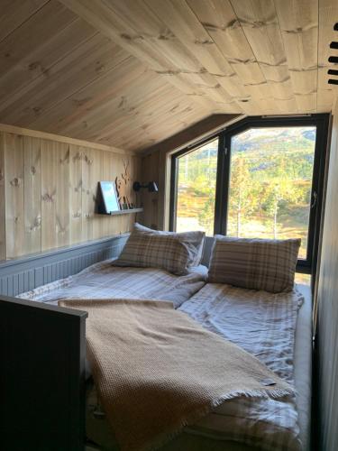 a bed in a small room with a window at Gaustablikk Sportshytte in Rjukan