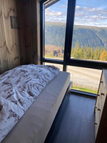 a bed in a room with a large window at Gaustablikk Sportshytte in Rjukan