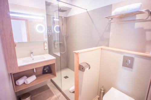a small bathroom with a sink and a shower at Hôtel et Appart Hôtel Les Flots Bleus in Agay - Saint Raphael