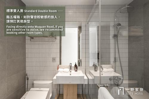 a bathroom with two sinks and a mirror at 1LI7E Hotel in Taichung