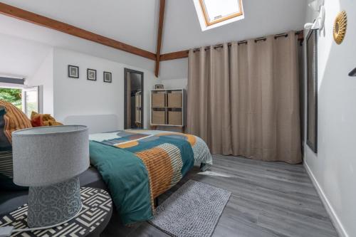 een slaapkamer met een bed, een lamp en een raam bij N° 8 - Metz City Centre - Travail & Loisirs in Metz