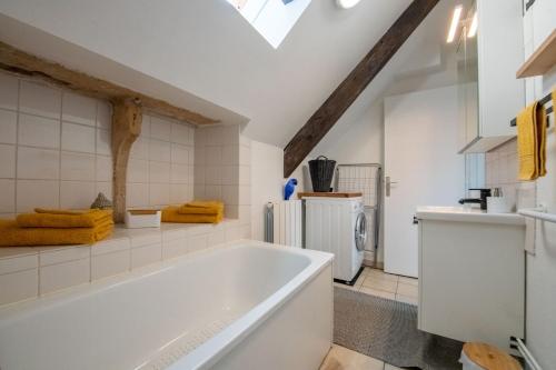 La salle de bains blanche est pourvue d'une baignoire et d'un lavabo. dans l'établissement N° 8 - Metz City Centre - Travail & Loisirs, à Metz