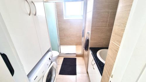 a small bathroom with a sink and a washing machine at Dream Escape Apt 1 - 6 min walk to Kastella Beach! in Larnaka