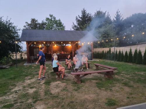 un grupo de personas sentadas alrededor de una mesa de picnic con una parrilla en Desant, 