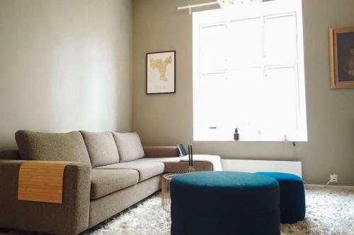 a living room with a couch and a blue stool at Central and modern apartment in Oslo in Oslo