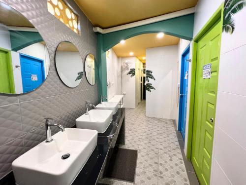 ein Badezimmer mit vier Waschbecken und zwei Spiegeln in der Unterkunft Sleepy Station Hostel in Kata Beach