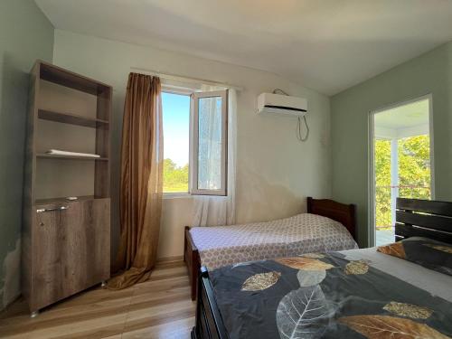 a bedroom with two beds and a window at TIANI Gest House in K'obulet'i