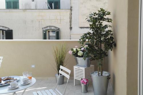 a balcony with two potted plants and a table at Vicolo Fiore Affittacamere in Matera