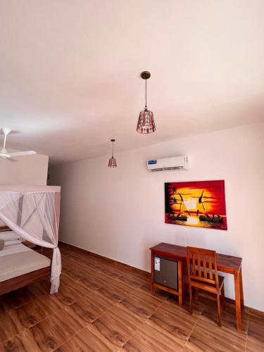 a living room with a bed and a table at S&S HOTEL in Jambiani