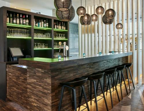 a bar with a row of stools in a restaurant at Holiday Inn Express Mechelen City Centre by IHG in Mechelen