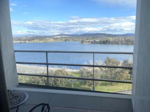 a view of a lake from a window at Stylish Central Lake View Apartment in Canberra