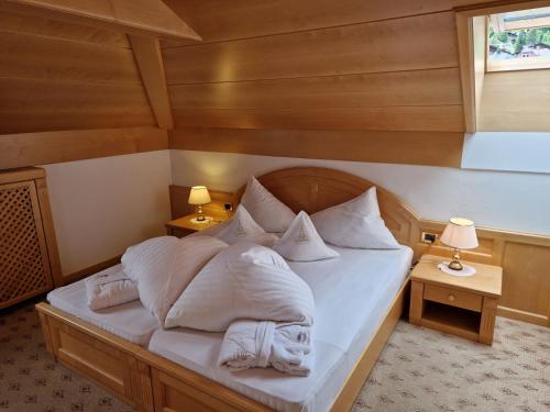 a bedroom with a bed with white sheets and pillows at Residence Ciastel in Ortisei