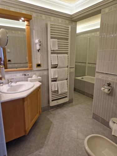 a bathroom with a sink and a tub at Residence Ciastel in Ortisei