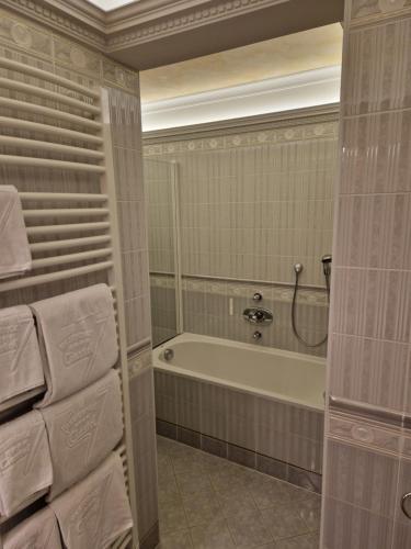 a bathroom with a tub and a shower and towels at Residence Ciastel in Ortisei