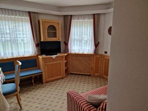 a living room with a tv and some windows at Residence Ciastel in Ortisei