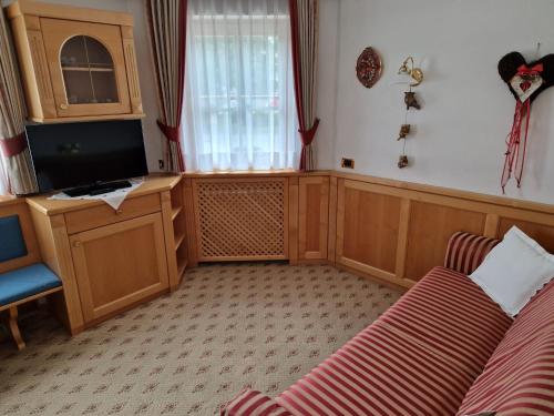 a living room with a couch and a television at Residence Ciastel in Ortisei