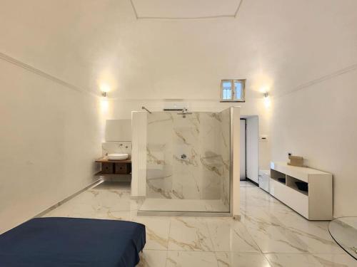 Camera bianca con letto e parete in marmo. di Anim Suite nel cuore di Ercolano a Ercolano