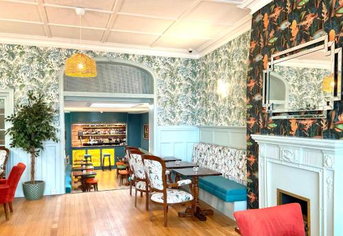 a dining room with a table and a fireplace at Ashton Court Hotel in Exmouth