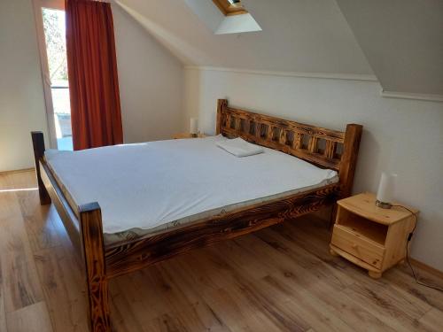 - une chambre avec un lit en bois et une table dans l'établissement Manyika Vendégház, à Balatonalmádi