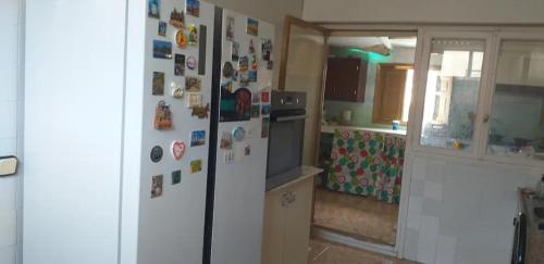 una cocina con nevera con muchos imanes en Habitación individual en Alicante