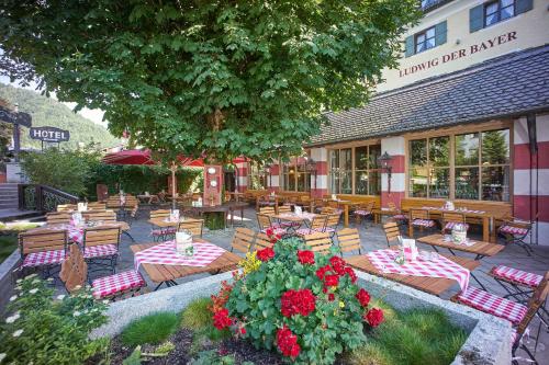 a patio with tables and chairs and a building at Hotel Klosterhotel Ludwig der Bayer in Ettal