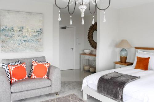 ein Schlafzimmer mit einem Bett, einem Sofa und einem Kronleuchter in der Unterkunft Seafront Apartment with Stunning Views in Cleethorpes