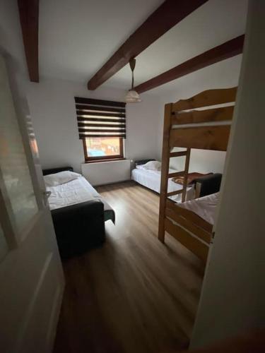 Sântimbru-Băi的住宿－Casă de vacanță în zona montană，一间卧室设有两张双层床和一扇窗户。