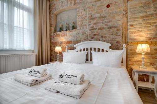 sypialnia z dużym białym łóżkiem z ręcznikami w obiekcie Dwie Wieże w mieście Międzyzdroje