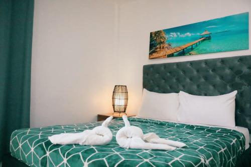 two swans laying on a bed in a bedroom at Maria Aliyah Events and Resort in Santa Cruz