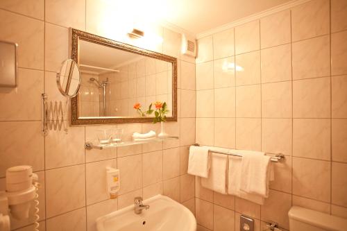 a bathroom with a sink and a toilet and a mirror at Safestay Berlin Kurfurstendamm in Berlin