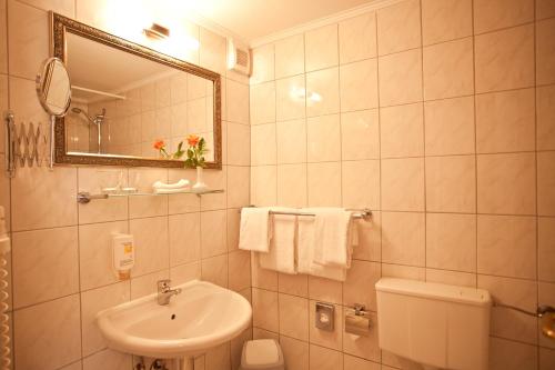 a white bathroom with a sink and a mirror at Safestay Berlin Kurfurstendamm in Berlin