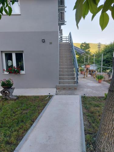 a stairway leading up to a white building with a clock tower at Rooms Sunny valley in Krupa