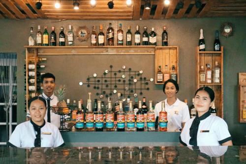 a group of people standing behind a bar with bottles of alcohol at Maria Aliyah Events and Resort in Santa Cruz