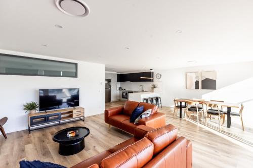 a living room with a couch and a table at Little Island Apartments in Hobart