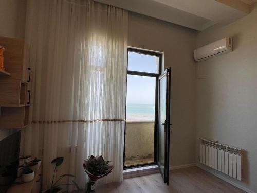 a room with a window with a view of the ocean at Caspian Pearl Residence in Sumqayıt