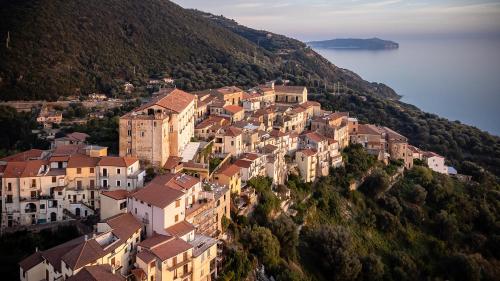 a group of buildings on a hill next to the water at Marulivo Hotel in Pisciotta