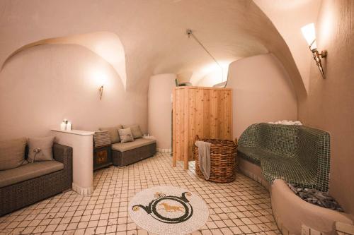 a small living room with a couch and a chair at Hotel Cavallino D'Oro Bed&Breakfast in Castelrotto