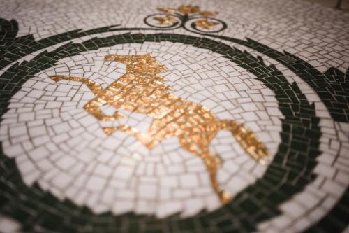 a mosaic floor with a horse on a floor at Hotel Cavallino D'Oro Bed&Breakfast in Castelrotto
