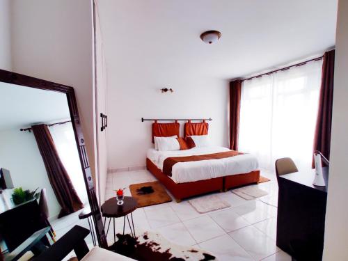1 dormitorio con cama y espejo en Man's Cave Abode en Nairobi